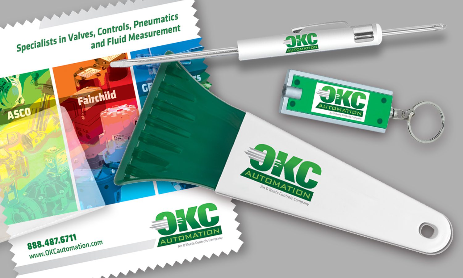 Premiums OKC Automation Branded giveaway items: A micro-fiber cloth and ppuch, a double-headed screwdriver, a keychain and an ice-scraper